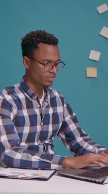 Dikey video: Finansal analist dizüstü bilgisayar ekranı önünde çalışmak için onay veriyor, onaylıyor ve doğru kararı veriyor. Genç yetişkin iyi yapıyor ve jestleri kabul ediyor, kendinden emin hissediyor..