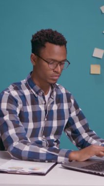 Dikey video: Hoşnutsuz analist kollarını kavuşturup hayal kırıklığı gösteriyor, iş kararına katılmıyor. Ofis işi hakkında yanlış bilgi aldıktan sonra bilgisayarı kapatan üzgün işçi.