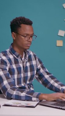 Dikey video: Şaşırtıcı işçi masada üç bilge maymun sembolü yapıyor, büyümeyi planlamak için dizüstü bilgisayar kullanıyor. Ofis çalışanı göz, ağız ve kulakları kapatıyor, kararın ardından şok oluyor..