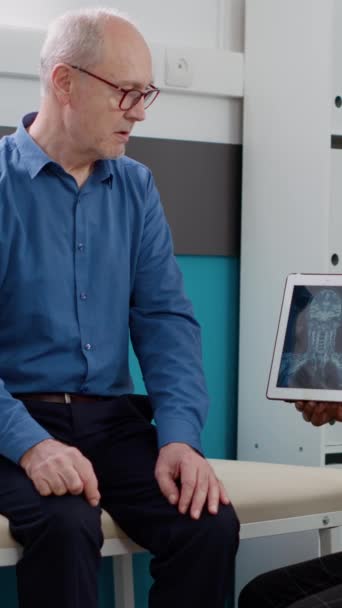 Dikey Video Afrikalı Amerikalı Doktor Yaşlı Adama Radyografi Sonuçlarını Analiz — Stok video