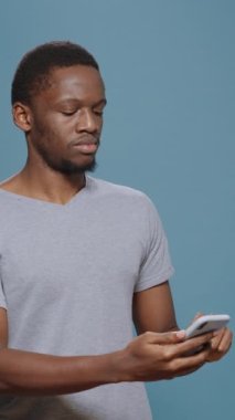 Dikey video: Hüsrana uğramış bir adam akıllı telefondan hayal kırıklığına uğramış, cep telefonundan internet sitesinden kötü haberler öğreniyor. Memnun olmayan yetişkin reddedilme ve hayal kırıklığıyla baş ediyor..
