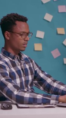 Vertical video: Overworked employee showing timeout gesture with hands, asking for break and pause from work at office desk. Tired person raising arms in defense, refusing to do job on laptop. Stop