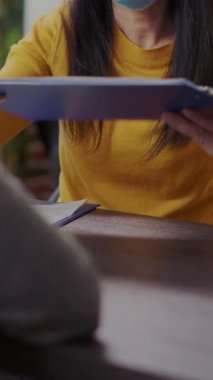 Vertical video: HR employee meeting with applicant at job interview during pandemic in business office. Company worker interviewing asian candidate, having CV resume and hiring contract on clipboard.