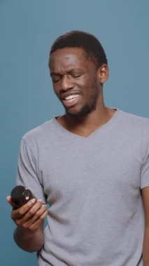 Dikey video: Hastalıkları tedavi etmek, antibiyotik kapsüller ve ilaç vitaminleri almak için bir şişe pilla ve ilaç analiz eden hasta yetişkin videosu. Reçeteli tedavi gören adam