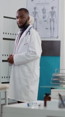 Dikey video: Yaşlı bir adam ecza dolabındaki check-up randevusunda doktordan ilaç tedavisi görüyor. Doktorlar hastalıkları ve sağlık hizmetlerini tedavi etmek için reçeteyle ilaç veriyorlar.