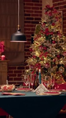 Dikey video: Samimi ve sıcak görünümlü yemek odası mevsimlik ve pozitifti ve içinde kimse yoktu. Orijinal dekorasyonlu geleneksel Noel yemeği masasının içi boş.