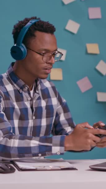 Вертикальне Відео Афроамериканець Використовує Джойстик Ноутбуці Щоб Грати Відеоігри Радіючи — стокове відео