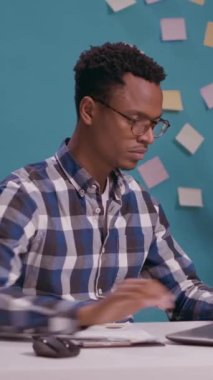 Dikey video: Satış danışmanı dizüstü bilgisayarda çalışıyor ve masasında iş çizelgeleri olan belgeleri analiz ediyor. Finansal analist istatistik ve grafiklerle kağıtlara bakıyor, pazarlama stratejisi yaratıyor.