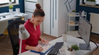 Business woman using data statistics on papers to plan project, analyzing sales research to create startup growth. Financial analyst working on executive presentation with charts and graphs.
