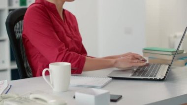 Şirket muhasebecisi not defterine not almak için satış raporunu kullanıyor, istatistik ve veri tablolarıyla finansal kalkınma planlıyor. Ofis çalışanı yönetim belgelerine yazı yazıyor.