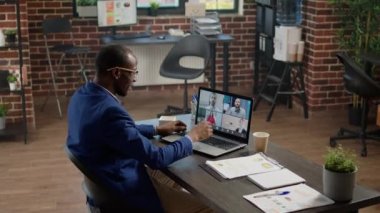 İş adamı strateji üzerinde çalışmak için insanlarla çevrimiçi video görüşmesi yapıyor. Çevrimiçi sohbet için uzak video konferansında konuşmak, dizüstü bilgisayarında webcam olan internet telekomünikasyonu.
