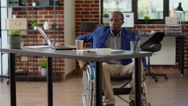 Sparaliżowany Pracownik Niepełnosprawnością Fizyczną Analizujący Statystyki Laptopie Użytkownik Wózka Inwalidzkiego — Wideo stockowe
