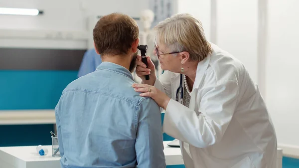 女性耳鼻咽喉科医は 医療キャビネットの患者を相談します 聴診器で耳の検査を行います 感染症や病気を治療するための耳鼻咽喉科ツールと耳薬の使用 — ストック写真