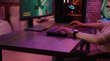 Beyaz kadın online aksiyon oyununda birinci oluşunu kendi evinden kutluyor. Profesyonel bilgisayar kurulumunda klavye ile uzay nişancısı simülasyonu oynayan oyuncu kız.