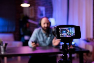 Modern ekipmanlarla çekim stüdyosunda podcast bölümü kaydetmek için kamera kullanarak video kaydedici. Çevrimiçi nüfuzlu kişi internet kanalında eğlenmek için canlı video kaydı yapıyor. Canlı yayın..