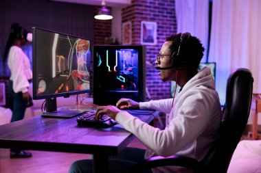 African american man playing action video games on stream online, using computer to play rpg tournament. Male gamer attending esport game championship to broadcast live gaming content.