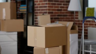 İçinde mobilya, lamba ve iç dekorasyon bulunan boş gayrimenkul eşyalarının olduğu mukavva kutular. Oturma odasında karton kutuları ve kargo paketleriyle kimse oturmuyor. Kapat..