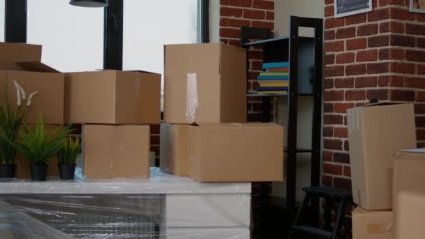 没有人在空荡荡的客厅里用纸板包装新家 家具堆放在纸盒里 没有人在家庭财产与包裹货物搬进来 房地产 — 图库视频影像