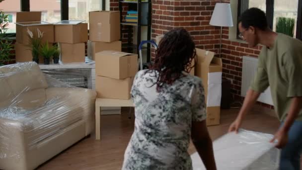 Pareja Afroamericana Que Lleva Muebles Para Decorar Nuevo Hogar Utilizando — Vídeo de stock