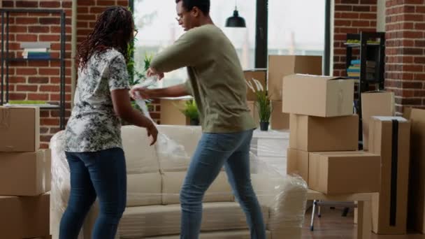 Africano Casal Americano Desempacotando Sofá Mobiliário Para Decorar Novo Apartamento — Vídeo de Stock