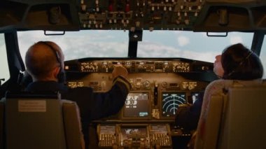 Pilot ve kadın yardımcı pilot torpido gözünde yükseklik ve boylam ayarlıyorlar, motor gazı ve kontrol paneliyle kalkışa hazırlanıyorlar. Uçak uçurmak için kokpit komutunu kullanmak. El kamerasıyla..
