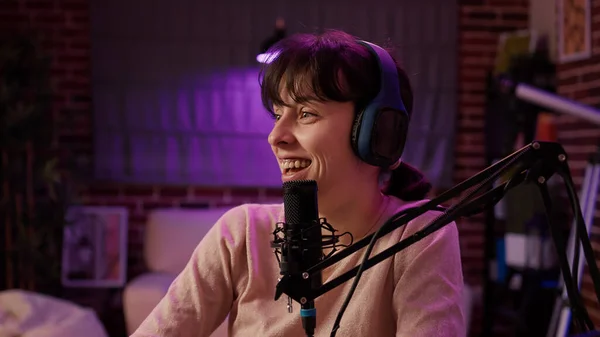 Portrait of online radio host recording interview with african american singer in late night entertainment show in home studio. Casual woman interviewing influencer using professional audio equipment.