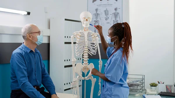 Female Nurse Analyzing Human Skeleton Bones Old Man Explaining Osteopathy — Photo