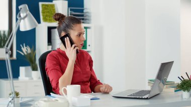 Executive manager talking on phone call with colleagues to plan startup project with charts and graphs. Sales consultant working on business development with smartphone conversation.