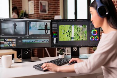 Video editor editing audio film montage with post production software on computer. Videographer working on movie footage edit with color grading and visual or sound effects at home.
