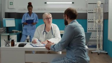 Sağlık görevlileri, check-up 'ta hasta hastalara ilaç ve destek vermek için reçete imzalıyorlar. Sağlık muayenesinde genç yetişkinlere ilaç tedavisi ve ilaçlarda yardım eden doktor.
