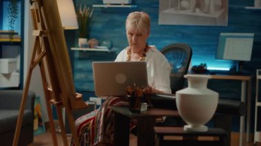 Retired artist finding drawing inspiration online on laptop to create vase sketch with artistic technique. Browsing internet to search model on computer, to draw professional artwork.