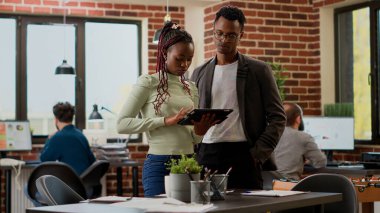 Afrika kökenli Amerikalı işçiler, iş yerindeki kağıtlar ve dijital tabletler hakkındaki bilgileri analiz ediyorlar. Araştırma verileri ile başlangıç projesini planlamak için şirket ortaklığı üzerinde çalışan meslektaşlar.