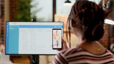 Akıllı telefondan iş arkadaşlarıyla görüntülü konuşma toplantısına katılan işletme öğrencisi uzaktan telekonferans ve webcam kullanarak. İnternetteki video konferansında insanlarla uzaktan konuşan bir kadın..