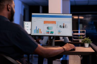 Executive manager looking at computer monitor with charts, analyzing statistics information and data to create project report, doing financial research. Pc screen with network presentation.