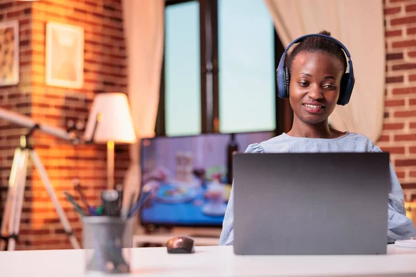 Młoda Afrykanka Słuchawkach Ogląda Filmy Laptopie Domu Uśmiechnięta Studentka Uczęszczająca — Zdjęcie stockowe