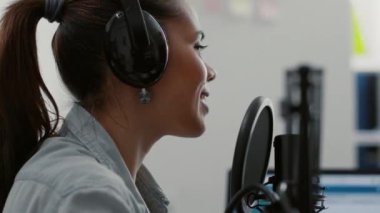 Ev stüdyosunda izleyicilerle konuşurken çekici bir talk-show sunucusu. Oturma odasında video yayını yaparken mikrofonda halka seslenen ünlü internet yıldızı.