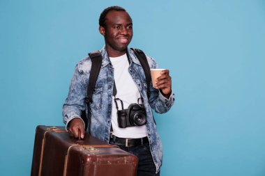 Professional photographer with camera and luggage ready for holiday urban citybreak. Happy young photography enthusiast with baggage and DSLR device going on vacation weekend trip.