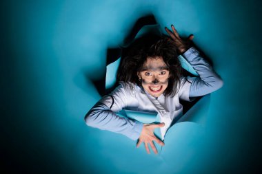 Crazy biochemistry specialist with dirty face and messy hairstyle grinning dreadful after laboratory explosion. Mad silly scientist with wacky hair and dirty face after dangerous explosion.