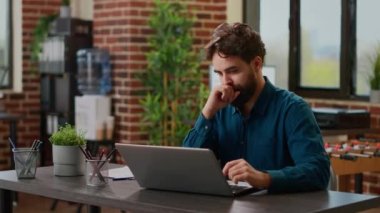 Project manager working on laptop to create business report, analyzing charts information and online data. Planning startup presentation with graphs on documents and paperwork. Handheld shot.