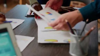 Business people looking at charts and diagrams on documents, analyzing research information on papers to plan office partnership. Colleagues using data infographics files. Close up.