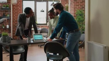 Diverse group of coworkers planning research analysis in business office, working on startup partnership to create project report with charts data and statistics. Using documents and digital tablet.