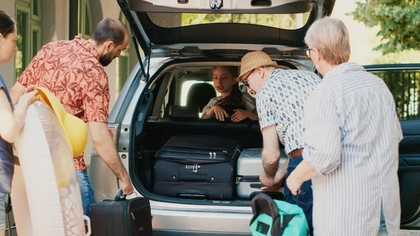 Casual Family Putting Voyage Trolleys Car Trunk While Getting Ready — Stockfoto