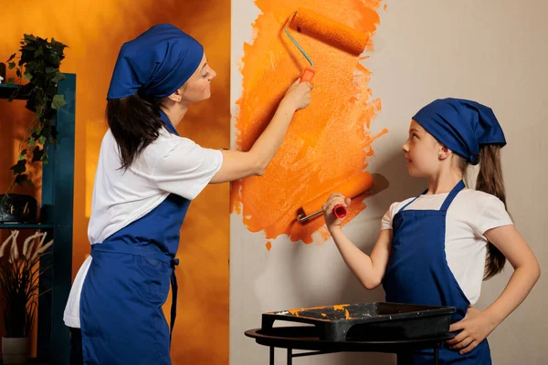 Small Family Using Roller Brush Paint Painting Room Walls Orange — Fotografia de Stock