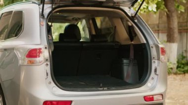 Married people loading baggage and trolleys inside car while going on field trip vacation. Casual couple putting voyage baggage inside vehicle trunk while getting ready for summer holiday citybreak.