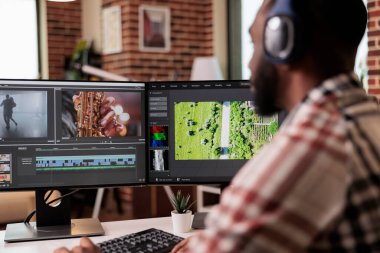 Graphic designer editing footage on software, working to edit video montage with color grading and audio effects. Sound and film production content, making creative movie on computer.