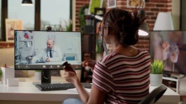 African american woman meeting with medic on videocall, attending telemedicine videoconference with webcam to discuss about healthcare and treatment. Online telehealth conference.