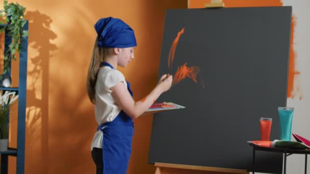 Νεαρό Παιδί Ζωγραφική Αριστούργημα Πορτοκαλί Χρώμα Και Πινέλο Χρησιμοποιώντας Καλλιτεχνικά — Αρχείο Βίντεο