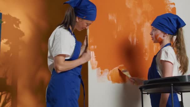 Mother Child Redecorating Apartment Orange Paint Color Using Paintbrush Apply — Stock video