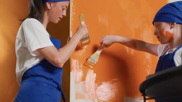 Small Family Painting Apartment Walls Diy Tools Using Paintbrush Orange — Vídeos de Stock