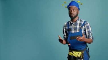 African american construction worker being dizzy and lightheaded, circle of stars above head concept. Engineer with hardhat, dizziness cartoonish style. 3d render animation.